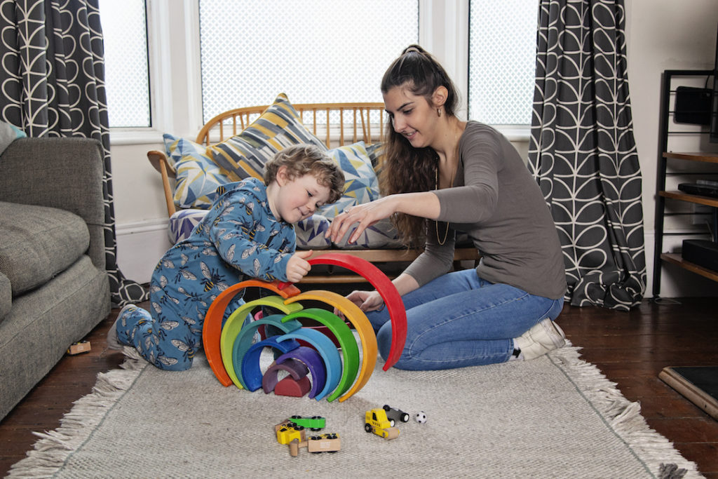Nanny and boy playing with rainbow toy