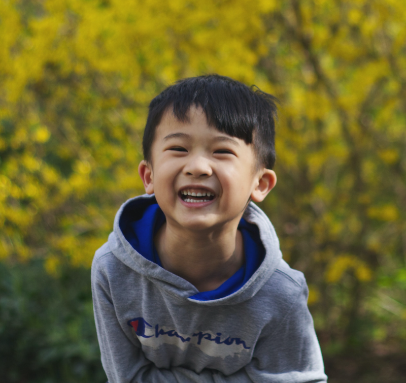 taking a study break is great for the brain, both for children and adults. The image shows a young boy outdoors, smiling.