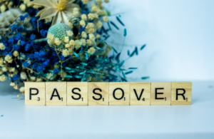 image with flowers and the word 'passover' spelled with scrabble tiles