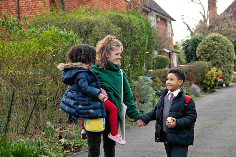 nanny and children on their way to school, dressed in their uniforms